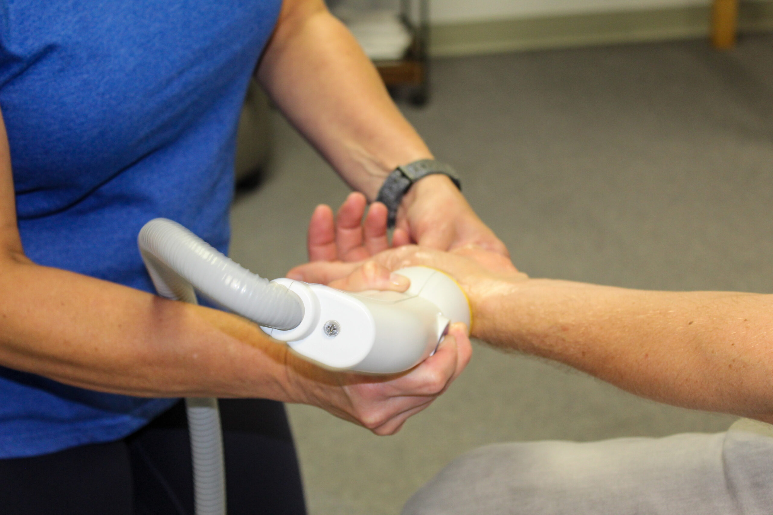 Image of the SoftWave machine being used on a wrist. 
